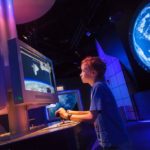 A young boy using a simulator at the Visitors Complex at the Kennedy Space Center.